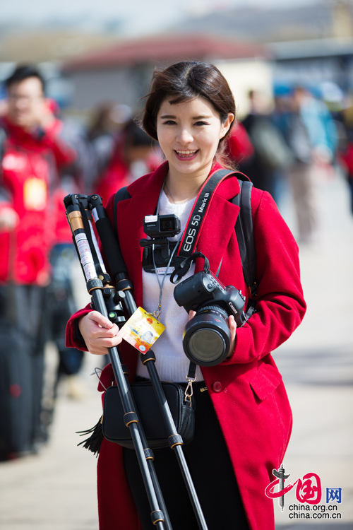 2016年兩會(huì)，人民大會(huì)大堂前,，一位笑容燦爛的紅衣女記者正步入大會(huì)堂,。中國(guó)網(wǎng) 鄭亮 攝